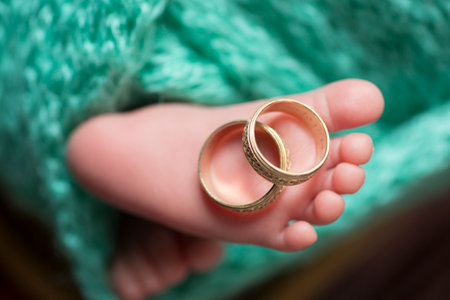 Wedding rings on the feet of a newborn baby girl.の写真素材