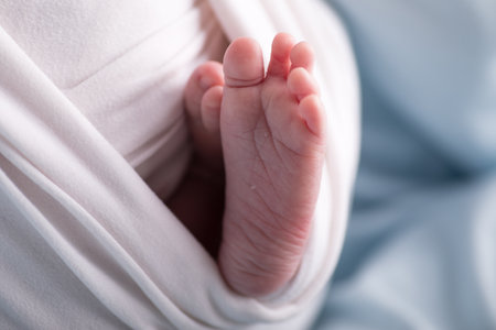 Newborn baby's foot on a white blanket, close-upの写真素材