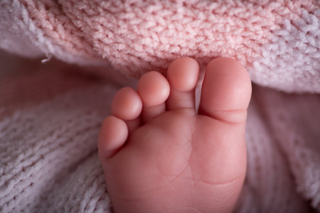 Feet of a newborn baby lying on a pink blanket, close-upの写真素材