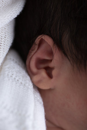 Close-up of a newborn baby's ear, shallow depth of field