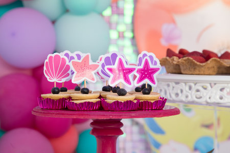 Birthday cupcakes decorated with blueberries and pink stars on a standの写真素材