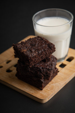 Chocolate brownies with glass of milk on black background, stock photoの写真素材