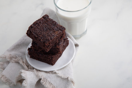chocolate brownies with a glass of milk on a white backgroundの写真素材
