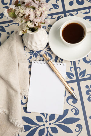 Cup of coffee, note book and napkin on the tableの写真素材