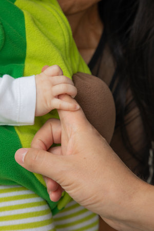 Closeup of a mother holding her baby in her arms at homeの写真素材