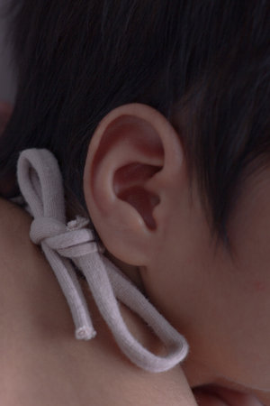 Close-up of a baby's ear with a white rope.
