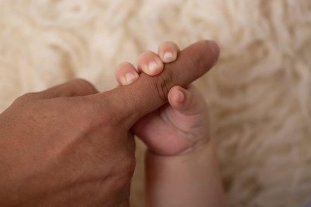 Closeup of newborn baby's hand and father's hand, shallow depth of fieldの写真素材
