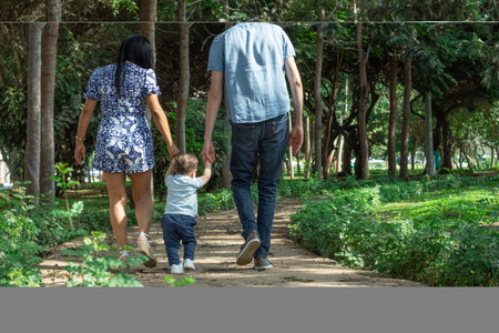 Happy family walking in the park. Father, mother and child.の写真素材