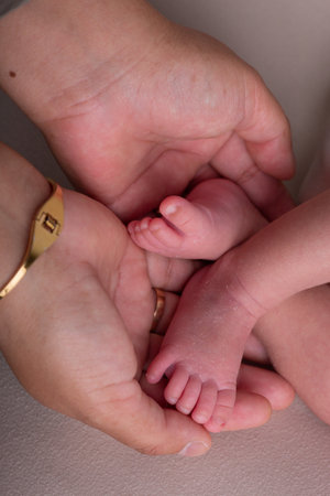 Newborn baby feet in mother's hands, close-up.