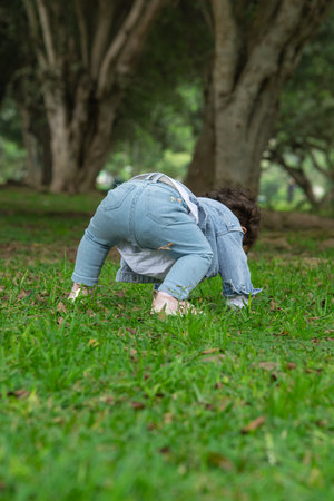 Little girl playing on the grass in the park with her legs upの写真素材