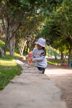 Little girl playing with her baby in the park. Selective focus.の写真素材