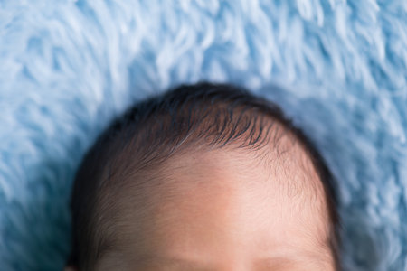 Newborn baby boy lying on a blue blanket. Close-up.の写真素材