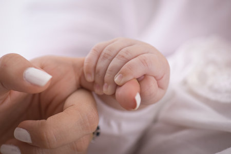 Newborn baby holding mother's hand, close up shot, soft focusの写真素材