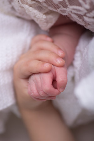 Newborn baby hand holding mother's hand. Shallow depth of fieldの写真素材