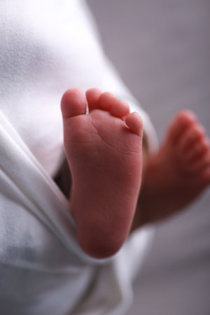 Newborn baby feet in a white towel. Shallow depth of fieldの写真素材