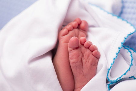 Newborn baby feet on a blue background. Close-up.の写真素材