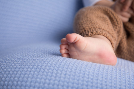 Newborn baby feet on a blue sofa, close-up.の写真素材