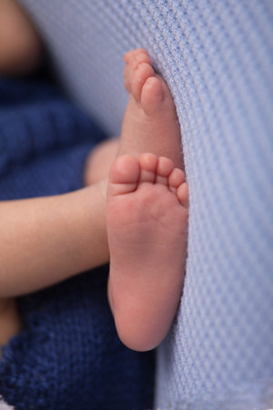 Baby feet in blue blanket, close-up. Baby care conceptの写真素材