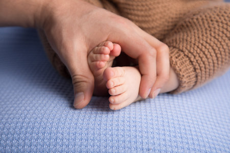 Newborn baby feet in mother's hands, close-up.の写真素材