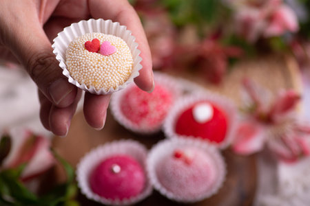 Valentine's day cupcake in hand on a wooden backgroundの写真素材
