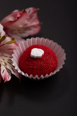 Chocolate candies with cream and flowers on a black background.の写真素材