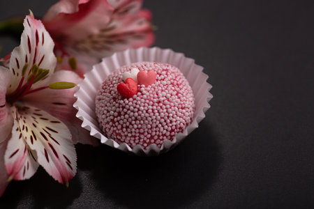 Brigadeiros Brasil Brasilianm dessert sweet food gourmet with pink lily flowers on a black backgroundの写真素材