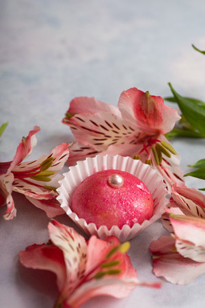 Brigadeiro traditional Brazilian Brasil sweet dessert Easter egg with pink flowers on a light background. Selective focus.の写真素材