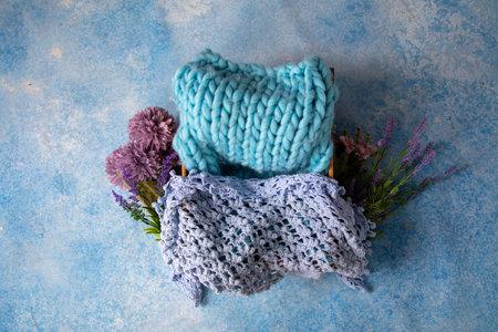 Blue knitted scarf with a bouquet of flowers on a blue background