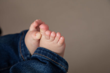 Baby feet on a gray background. Close-up of the toes of a child