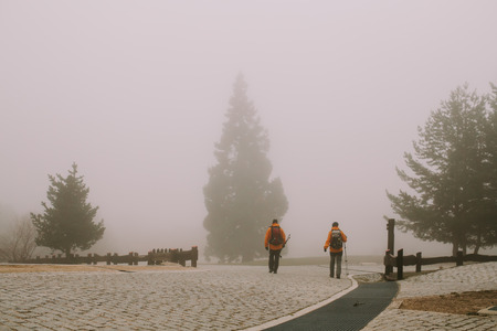 Two mountaineers walk in the thick fogの写真素材