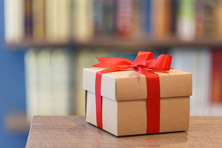 Gift box with red ribbon bow on wooden backgroundの写真素材