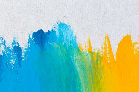 Blue and yellow watercolor on cement wallの写真素材