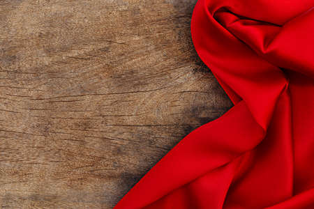Red satin fabric on brown wood background. Valentines day backgroundの写真素材