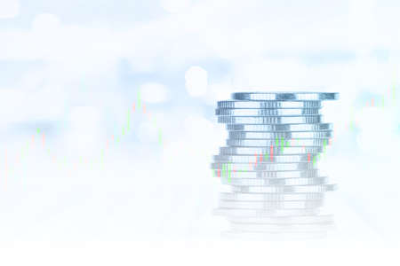 Coin stacks with stock market graph backgroundの写真素材
