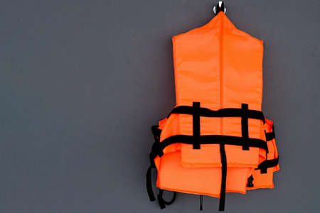 Orange life jacket on grey backgroundの写真素材