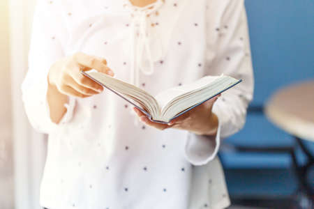 Young woman reading book in the houseの写真素材