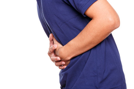 Man having painful stomach ache isolated on white background. Healthcare and health problem conceptの写真素材