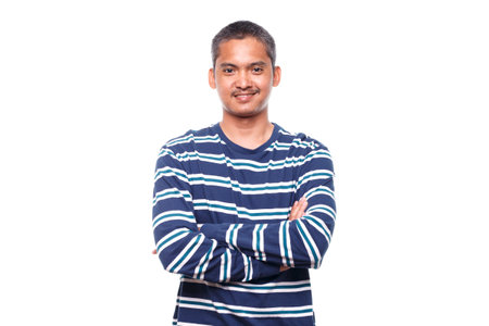 Portrait of young smiling man with crossed arms isolated on white  backgroundの写真素材