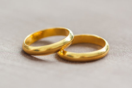 Two wedding gold rings on brown background
