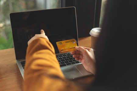 Woman holding credit card and using laptop computer. Online shopping, internet bankingの写真素材