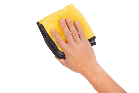 Hand holding a yellow and gray microfiber cloth for cleaning, isolated on white background.の写真素材