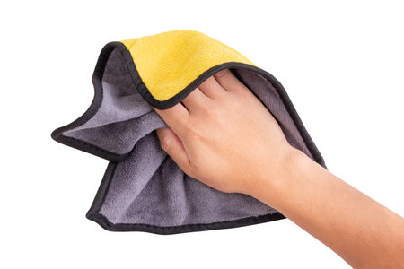 Hand holding a yellow and gray microfiber cloth for cleaning, isolated on white background.  designed for dustingの写真素材