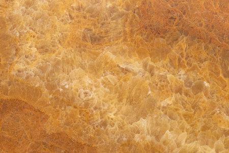 Golden onyx marble texture with natural stone veins and warm amber tones, ideal for interior surfaces, countertops, and design backgrounds.の写真素材