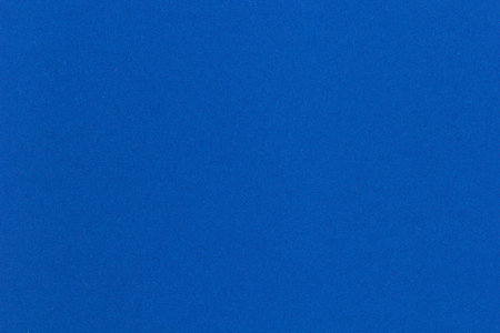 Solid blue paper texture with soft grain surface, ideal for creative backgrounds, graphic design, and craft presentations.の写真素材