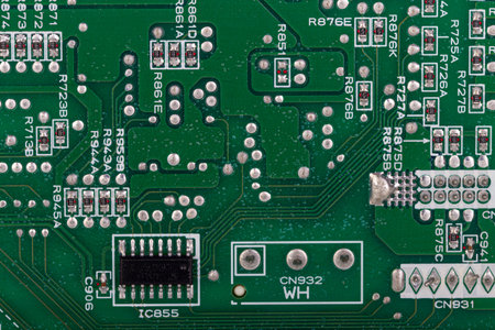 Detailed macro shot of a green printed circuit board (PCB) with microchips, resistors, and electronic components. Ideal for illustrating technology, electronics, and innovation concepts.の写真素材