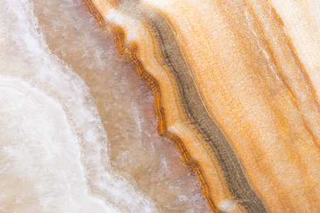Natural onyx marble texture featuring layered beige, brown, and golden tones, perfect for interior design, tiles, and luxury backgrounds.の写真素材