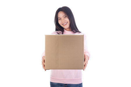 Smiling Asian woman holding and presenting a cardboard box toward the camera. Concept of delivery,...