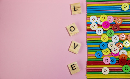 Love message written in wooden blocks placed on pink backgroundの写真素材