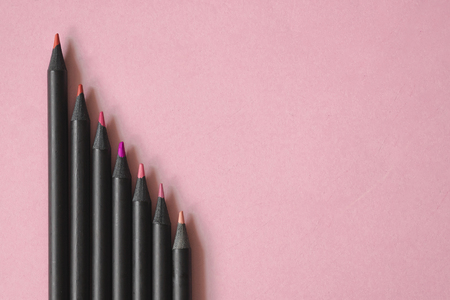 pink, red and violet tone colour of black pencils on pastel pink backgroundの写真素材