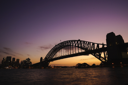 silhouette view of Sydney Harbour Bridge on colourful twilight sky.